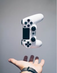 Image depicting a Playstation controller falling into a person's hand